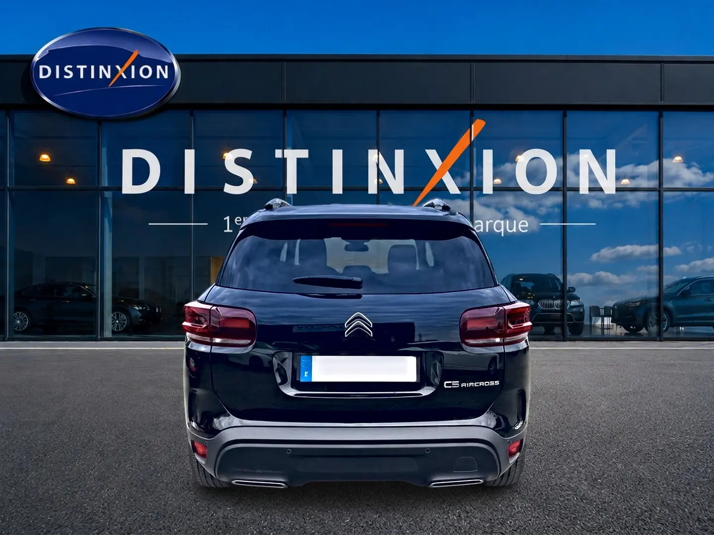 Vue arrière d'un Citroën C5 Aircross noir 2025 avec feux LED et barres de toit visibles devant une vitrine Distinxion.