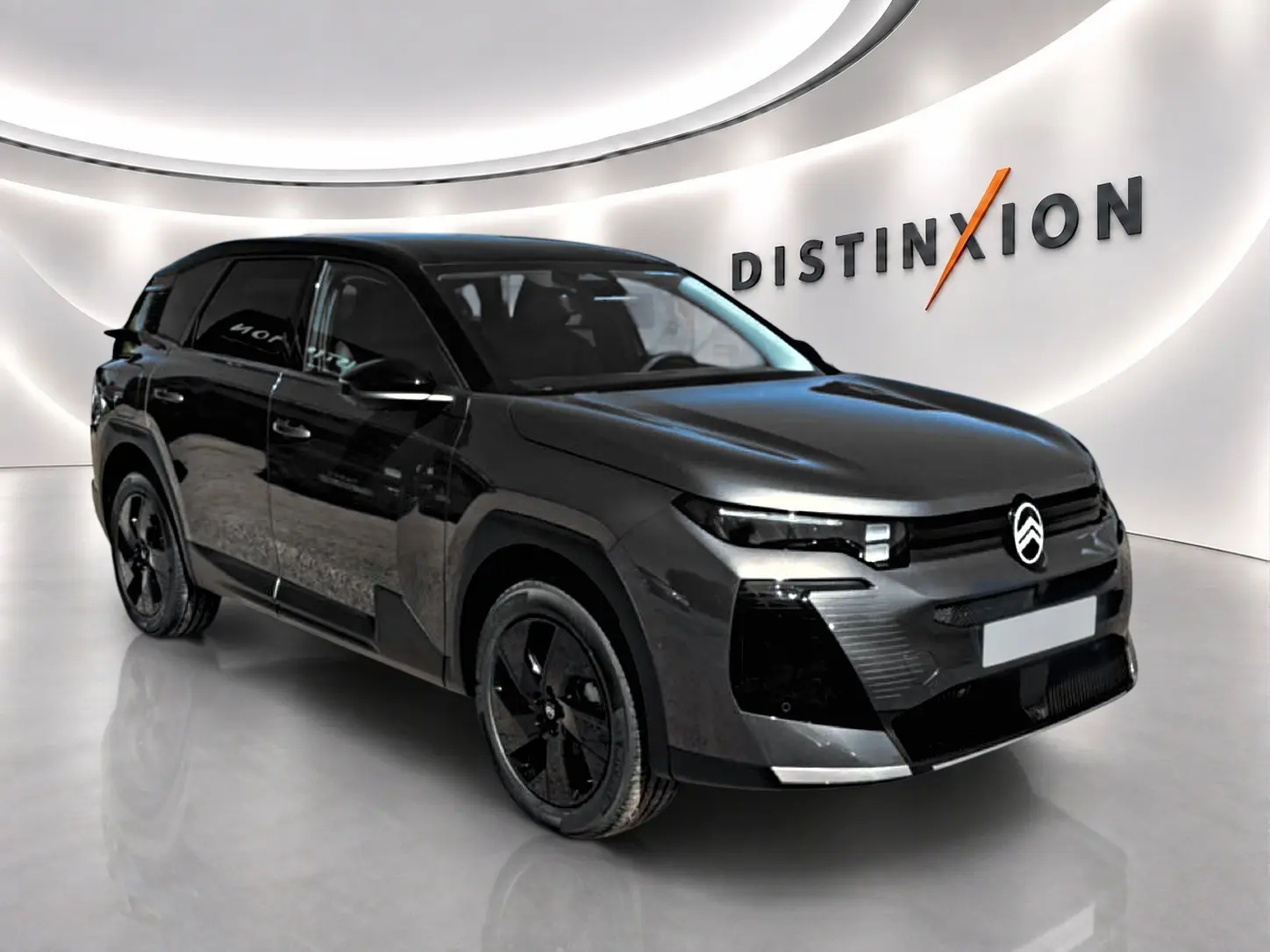 Citroën C5 Aircross 2026 gris platinium vue 3/4 avant droit dans un showroom lumineux avec toit noir.
