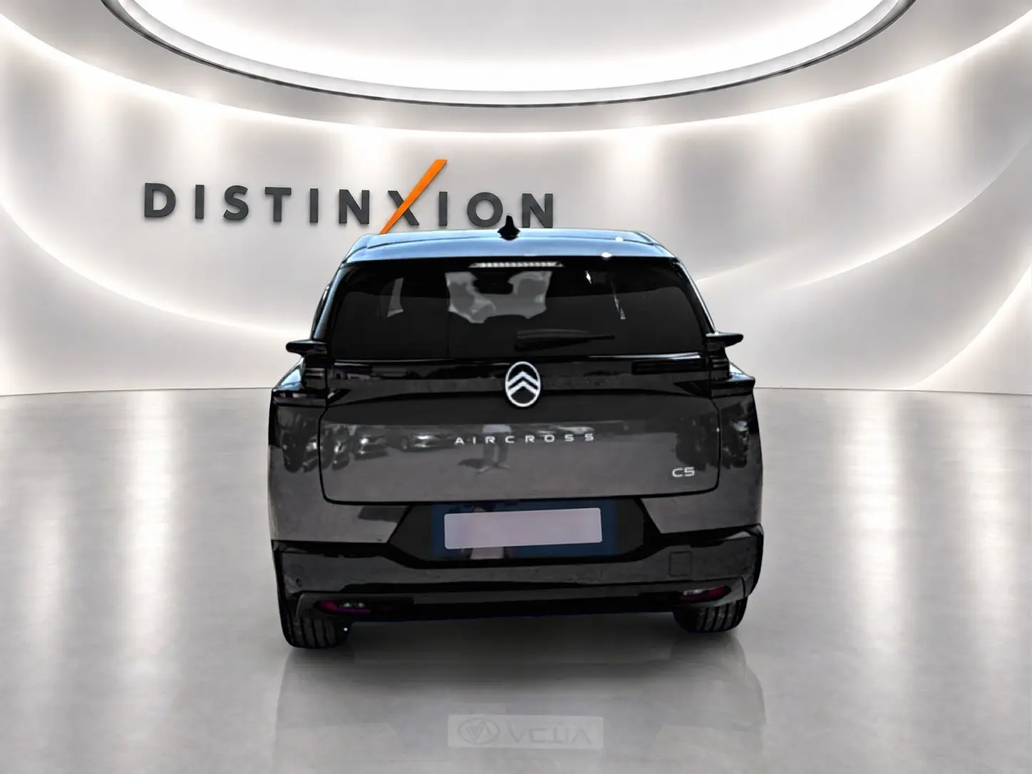 Vue arrière d’un Citroën C5 Aircross gris platinium avec toit noir, dans un showroom lumineux au logo Distinxion.