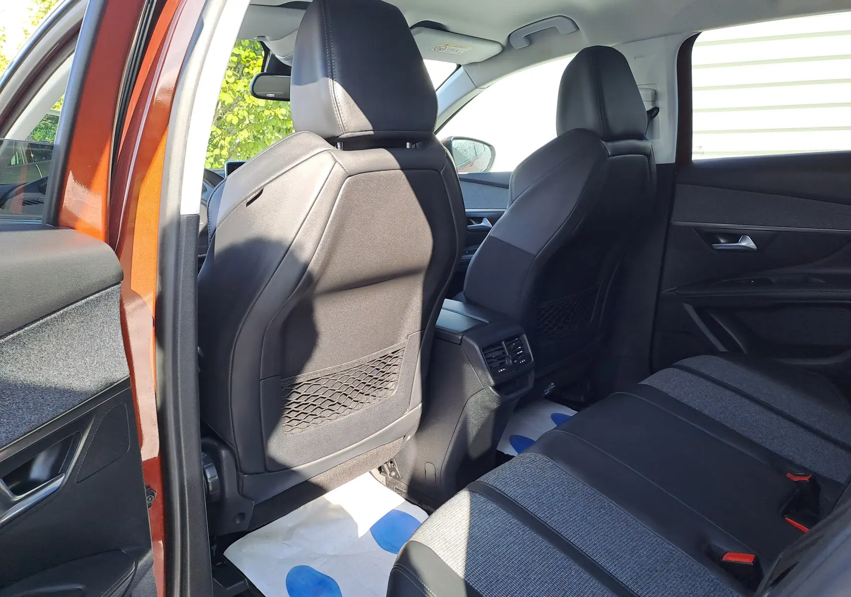 Vue intérieure arrière droite du Peugeot 3008 2019 metallic cooper, sièges tissu et cuir gris avec appuie-têtes noirs.