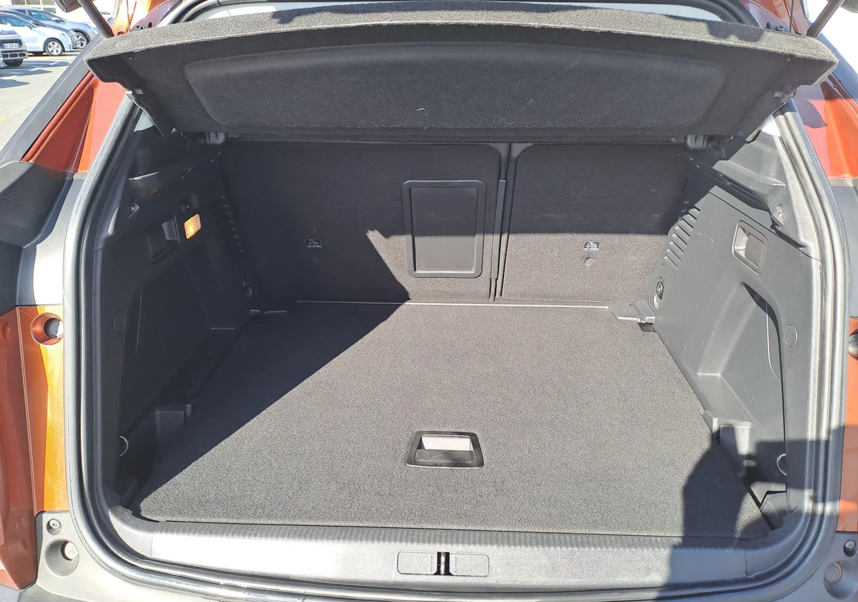 Coffre ouvert du Peugeot 3008 2019 métallisé copper, vue arrière montrant un espace de chargement propre et spacieux.