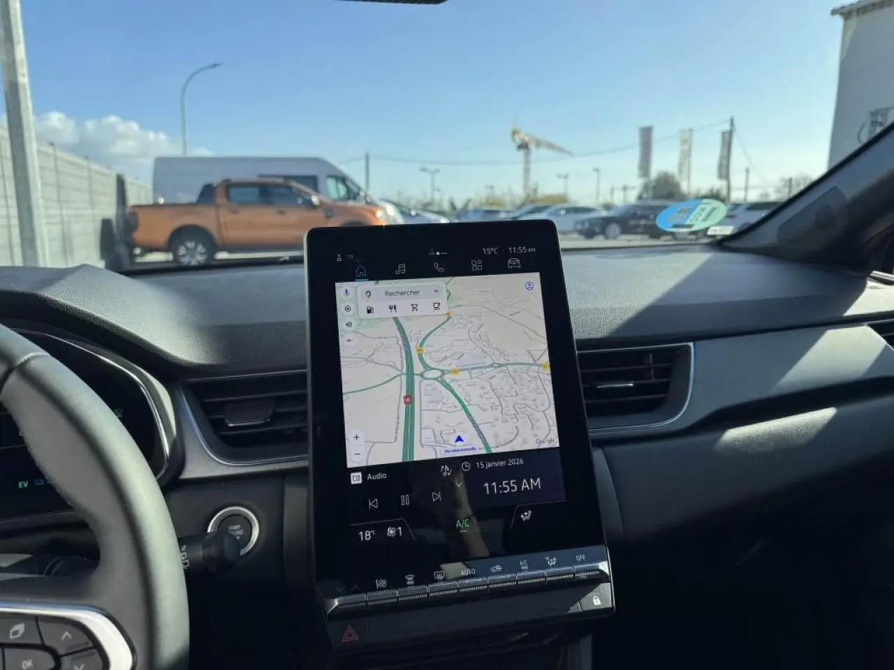 Vue intérieure du tableau de bord du Renault Captur gris Cassiopée, avec écran tactile central affichant la navigation.