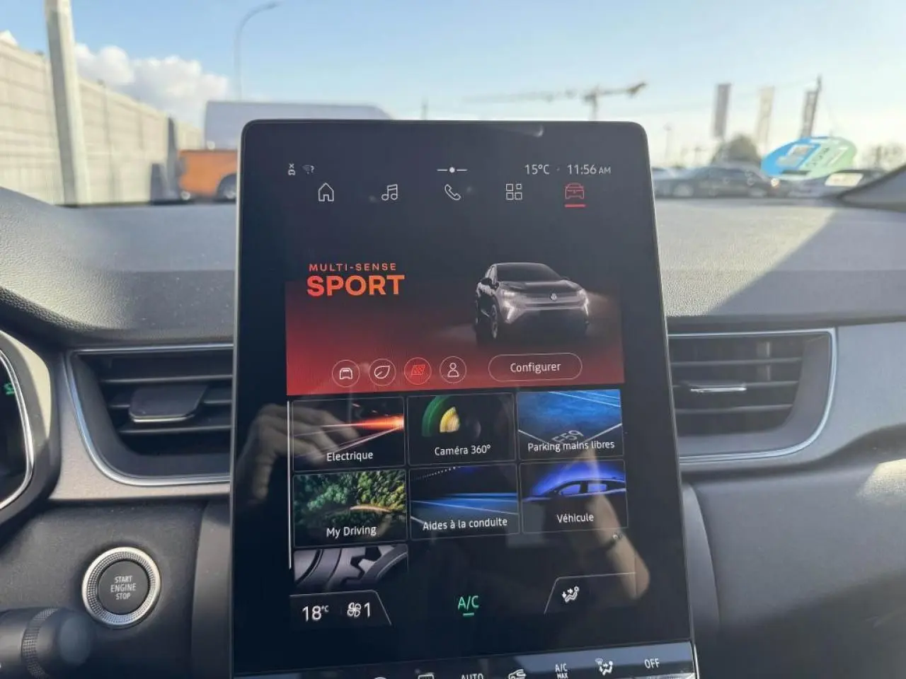 Vue intérieure centrée sur l'écran tactile du tableau de bord du Renault Captur gris Cassiopée, mode Sport affiché.