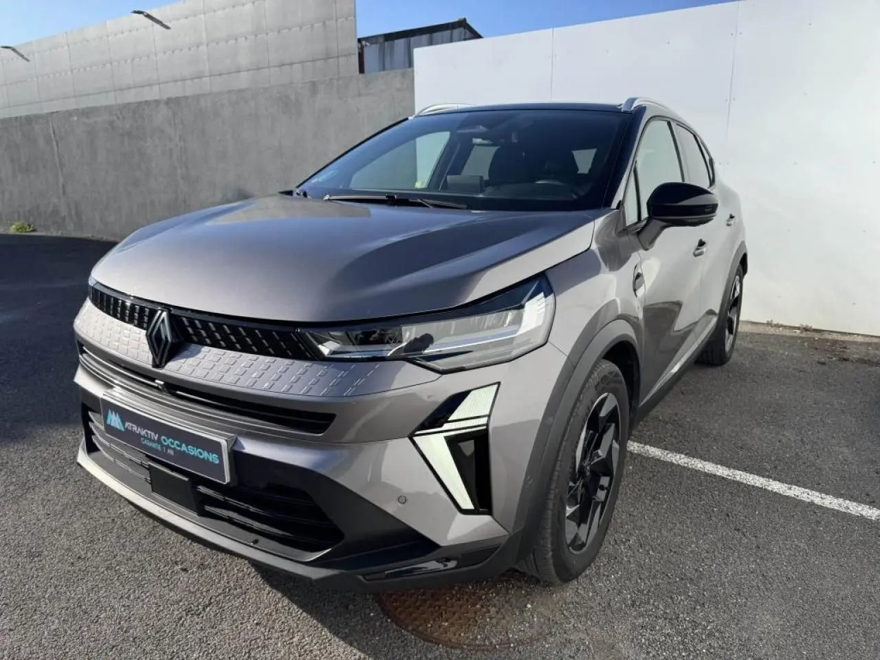 Renault Captur II gris Cassiopée avec toit noir, vue 3/4 avant droit, jantes aluminium et éclairage LED distinctif.