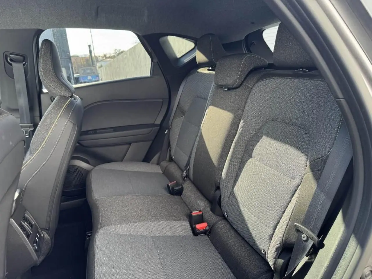 Vue intérieure côté droit sur la banquette arrière grise du Renault Captur II hybride avec appuis-tête réglables.