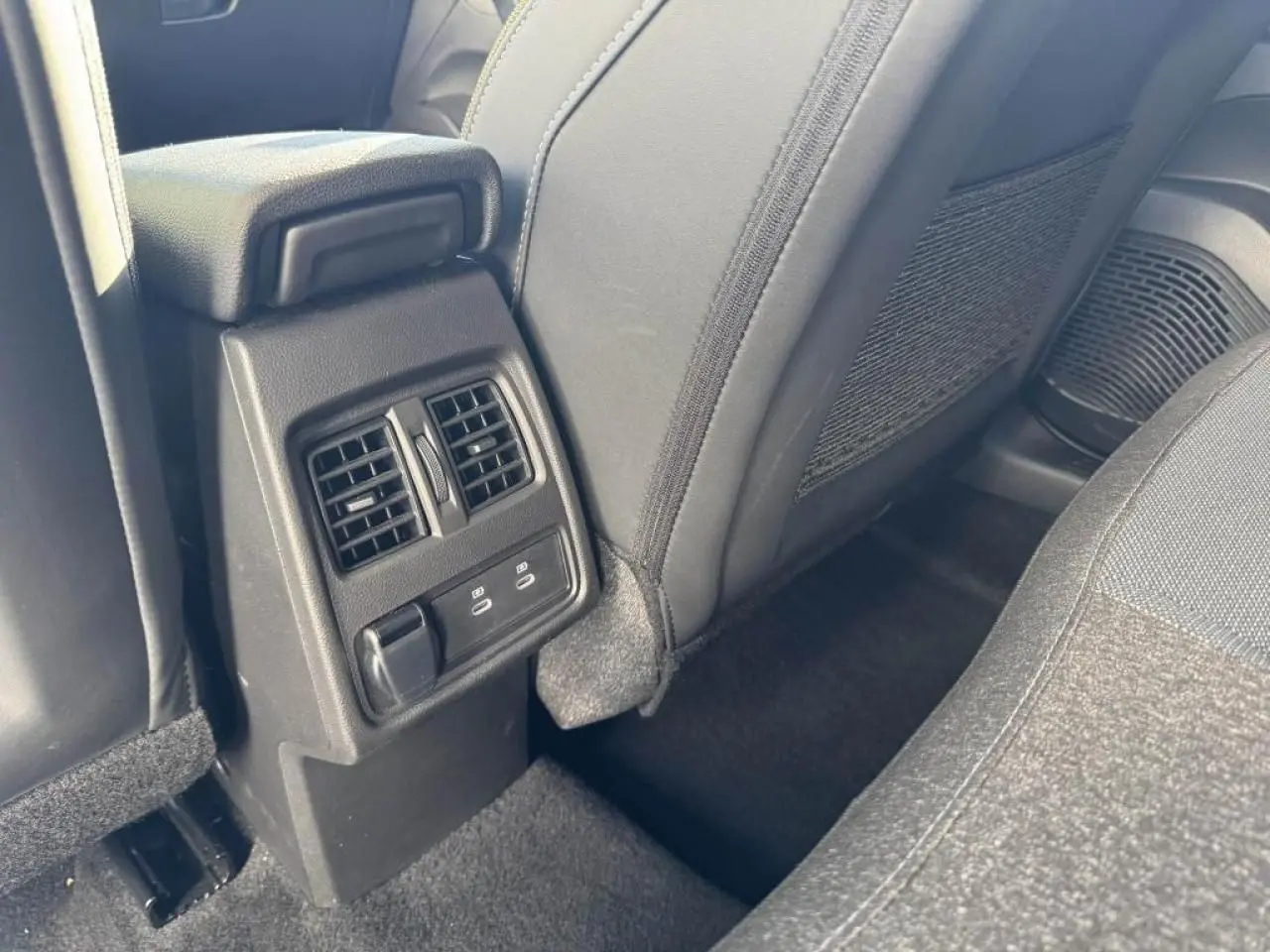 Vue rapprochée de la console arrière avec bouches d’aération et prises USB C dans l’habitacle du Renault Captur gris.