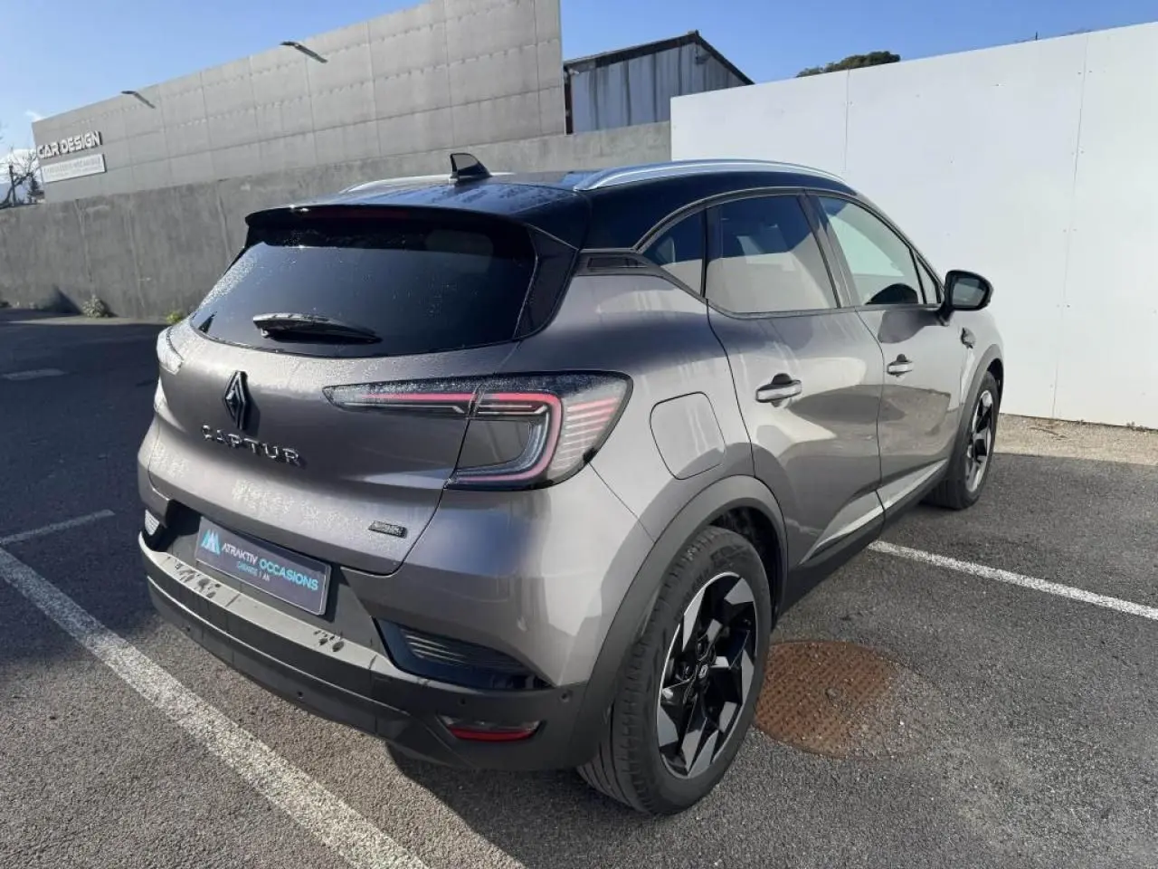 Vue 3/4 arrière droite du Renault Captur gris Cassiopée avec toit noir et jantes aluminium noires.