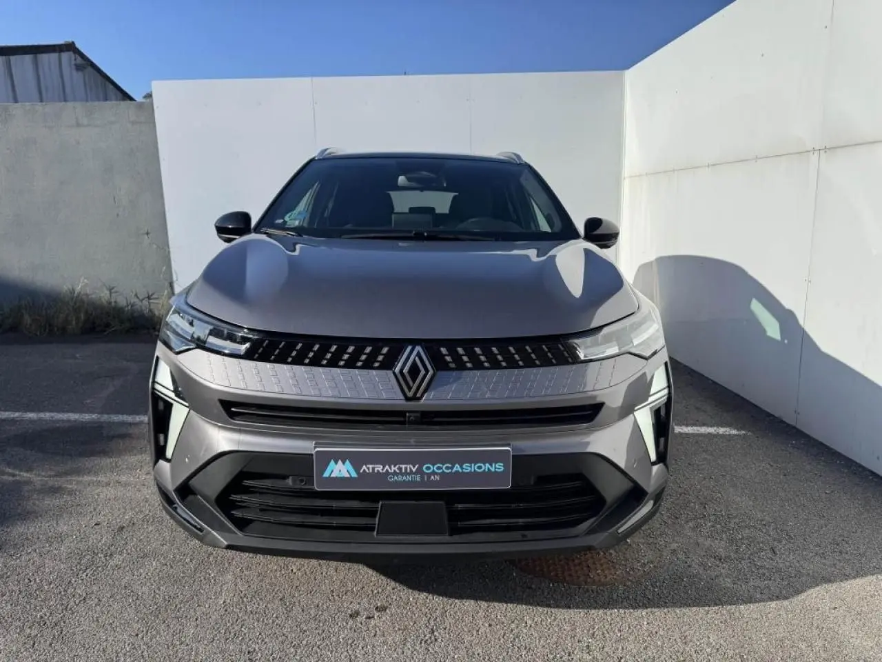 Vue frontale du Renault Captur II gris Cassiopée avec toit noir, mettant en valeur la calandre et les phares LED.