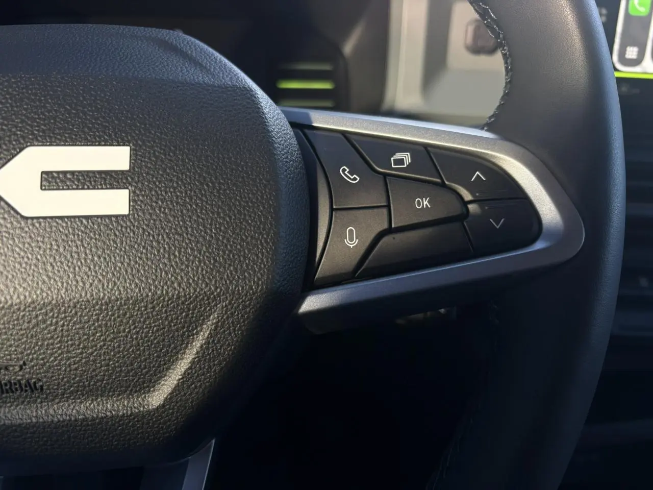 Gros plan sur les commandes au volant à droite du Dacia Duster 2025, finition Extrême, avec détails en brun cuivré.