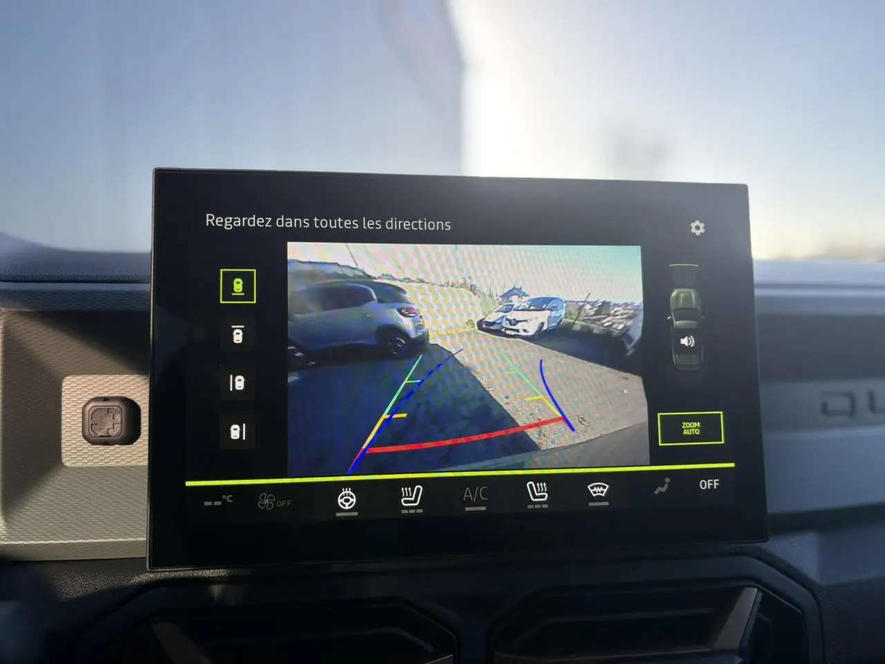Écran tactile intérieur du Dacia Duster 2025 affichant la caméra 360° avec vue arrière et lignes de guidage colorées.