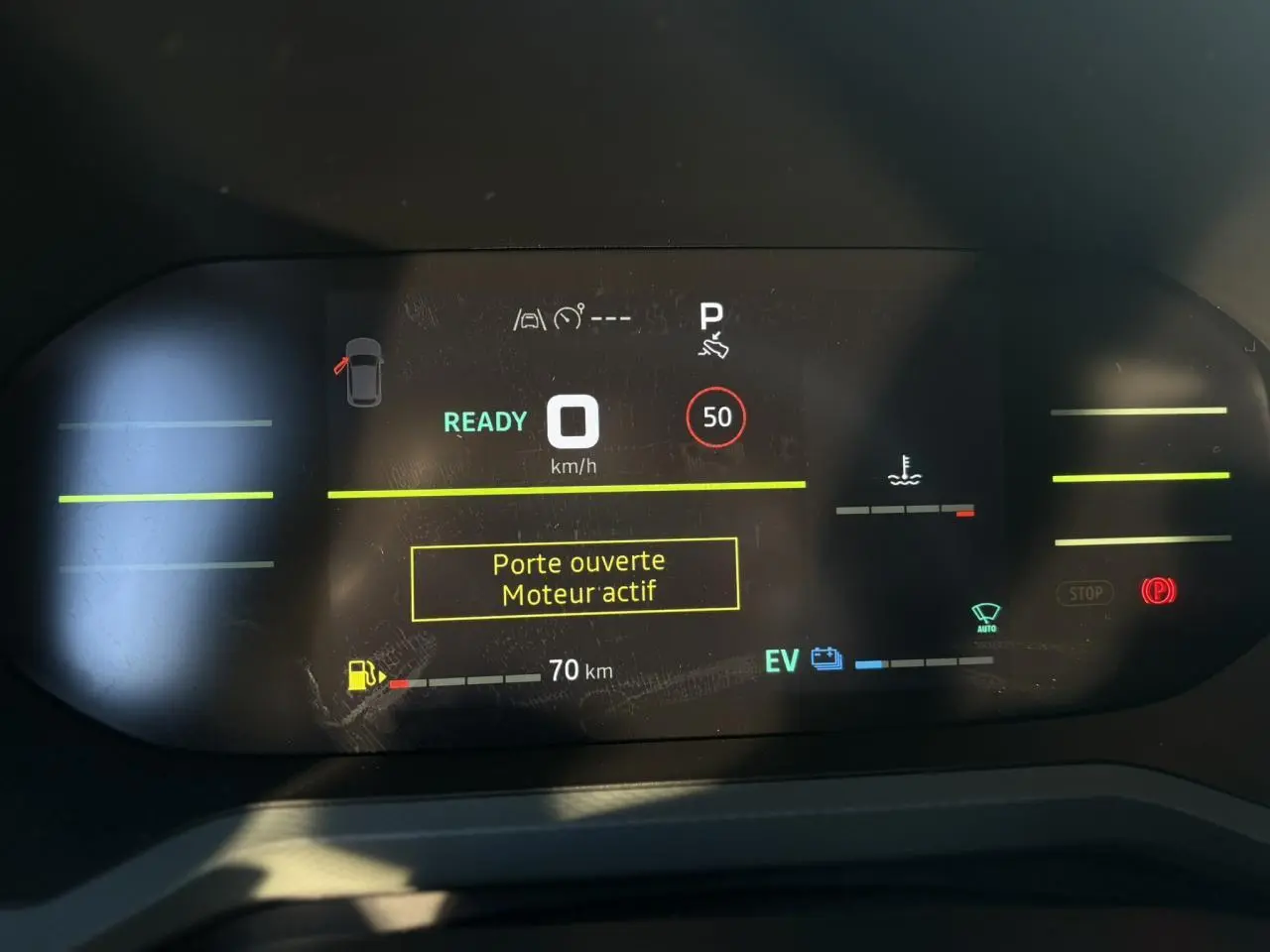 Affichage digital du tableau de bord du Dacia Duster 2025, indiquant porte ouverte et moteur actif.