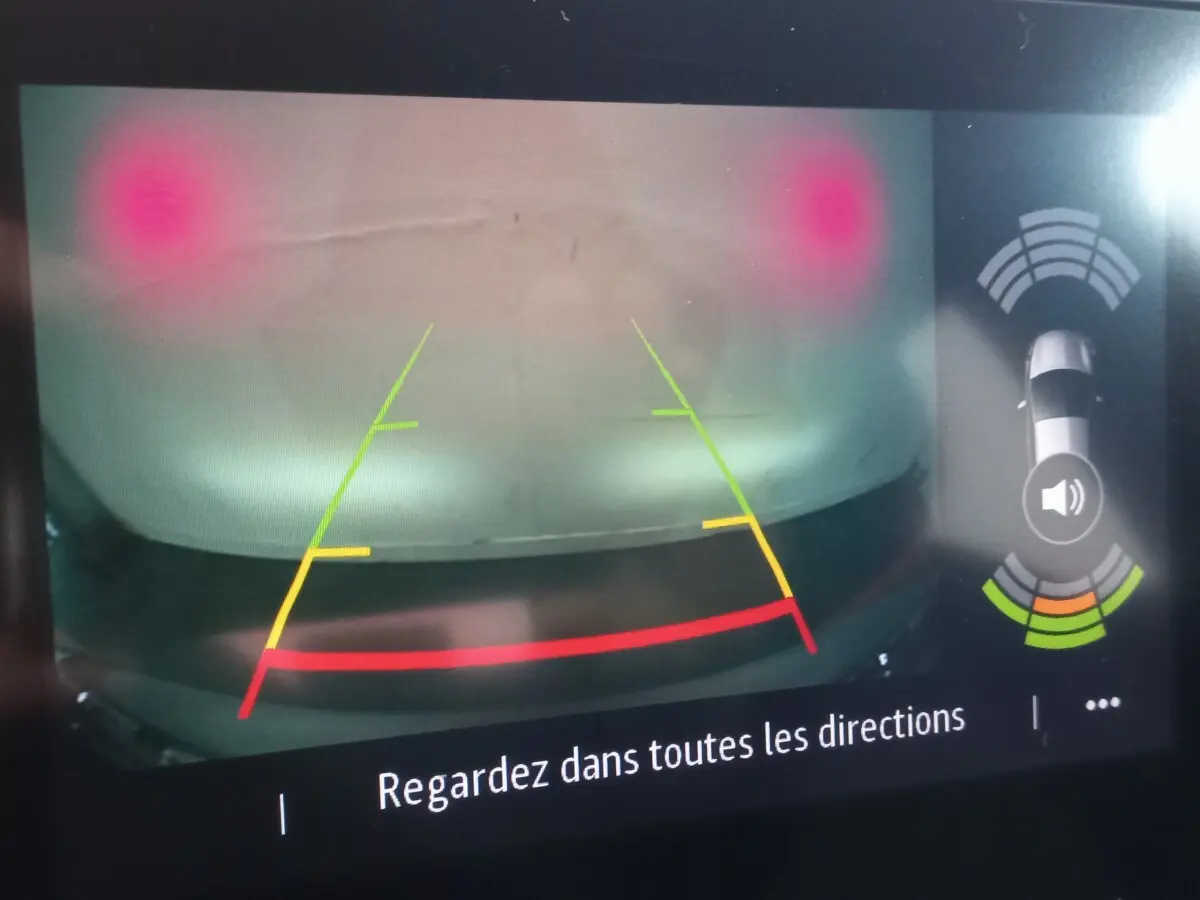 Affichage caméra de recul du Renault Captur gris clair montrant obstacle proche avec lignes de guidage colorées.