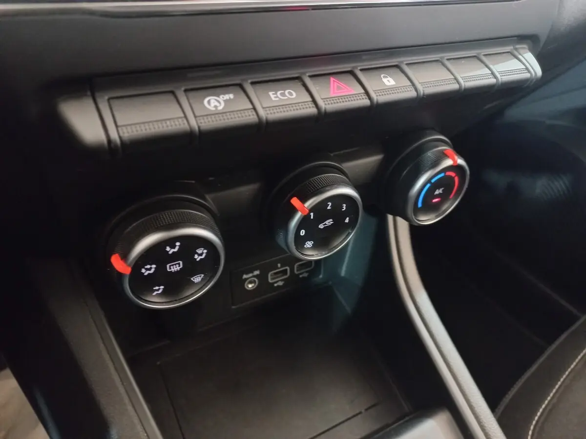 Gros plan sur les commandes de climatisation et boutons fonctionnels du tableau de bord du Renault Captur Business TCe 100 gris clair.