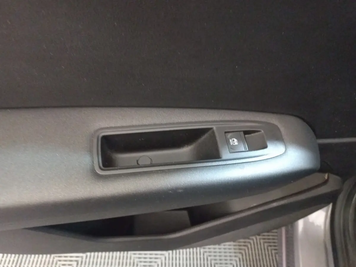 Détail de la poignée intérieure et bouton de verrouillage de porte côté gauche d'un Renault Captur gris clair 2020.