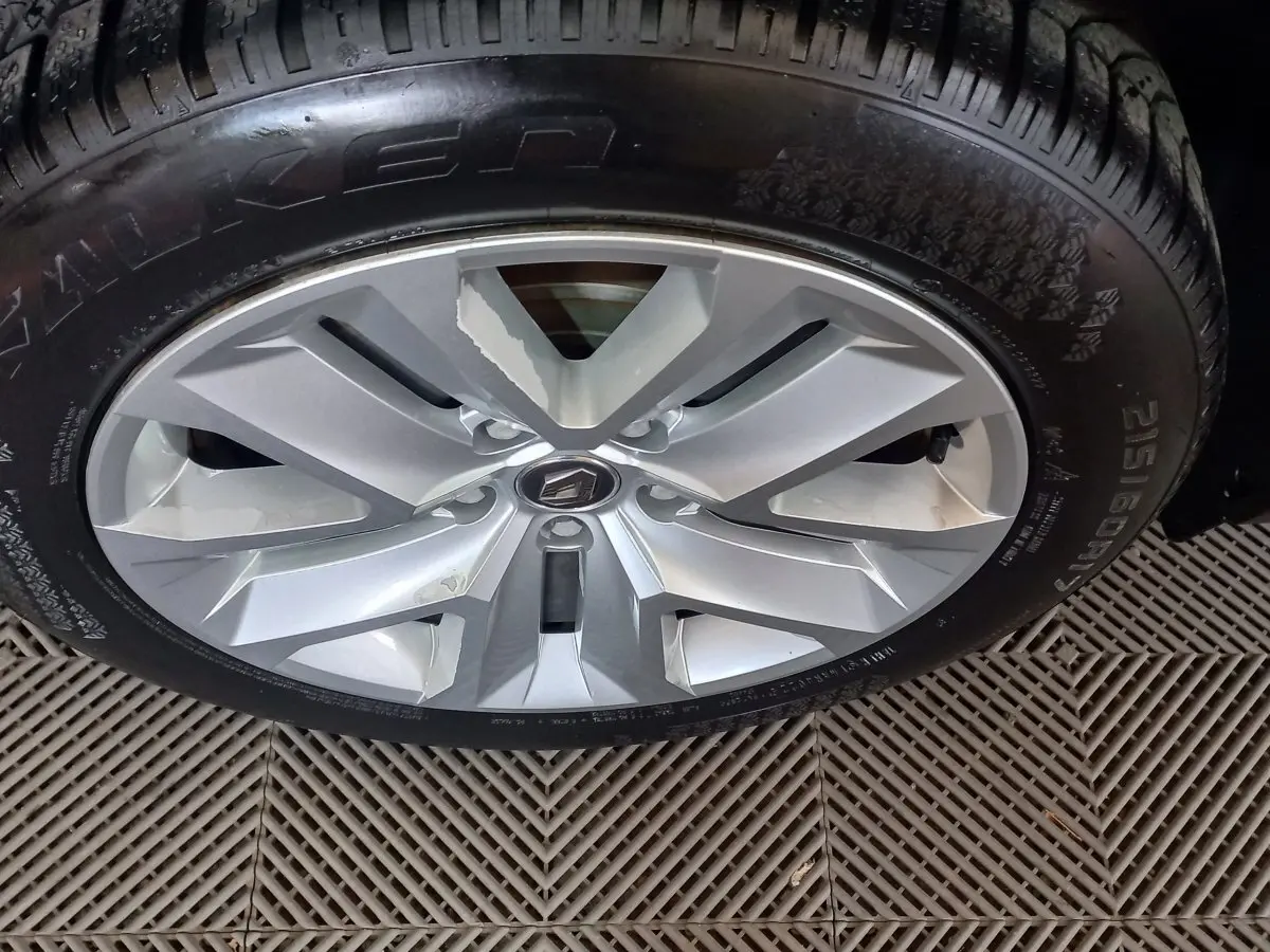 Gros plan sur la jante argentée avec logo Renault d'un Renault Captur gris clair, pneu Falken visible.