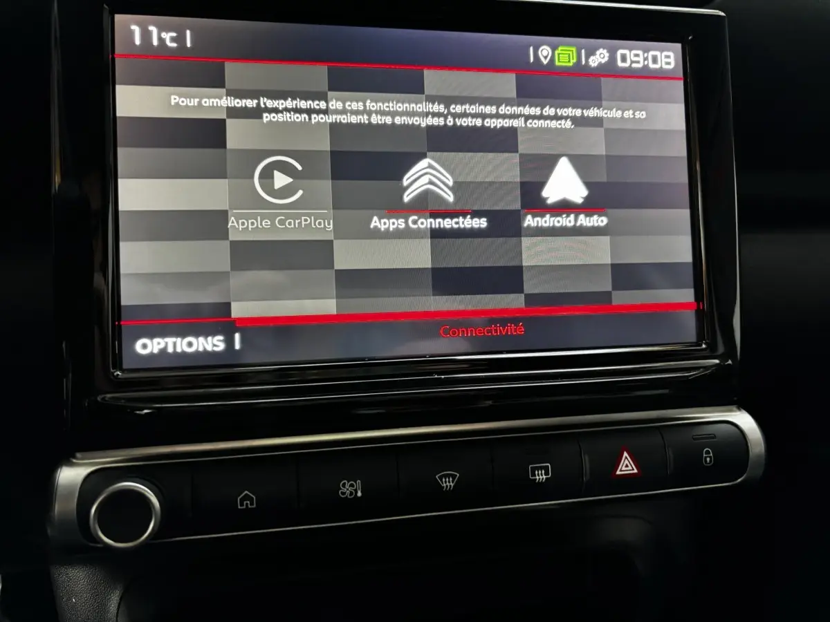 Écran tactile central affichant Apple CarPlay et Android Auto dans l'habitacle d'une Citroën C3 Aircross gris foncé.
