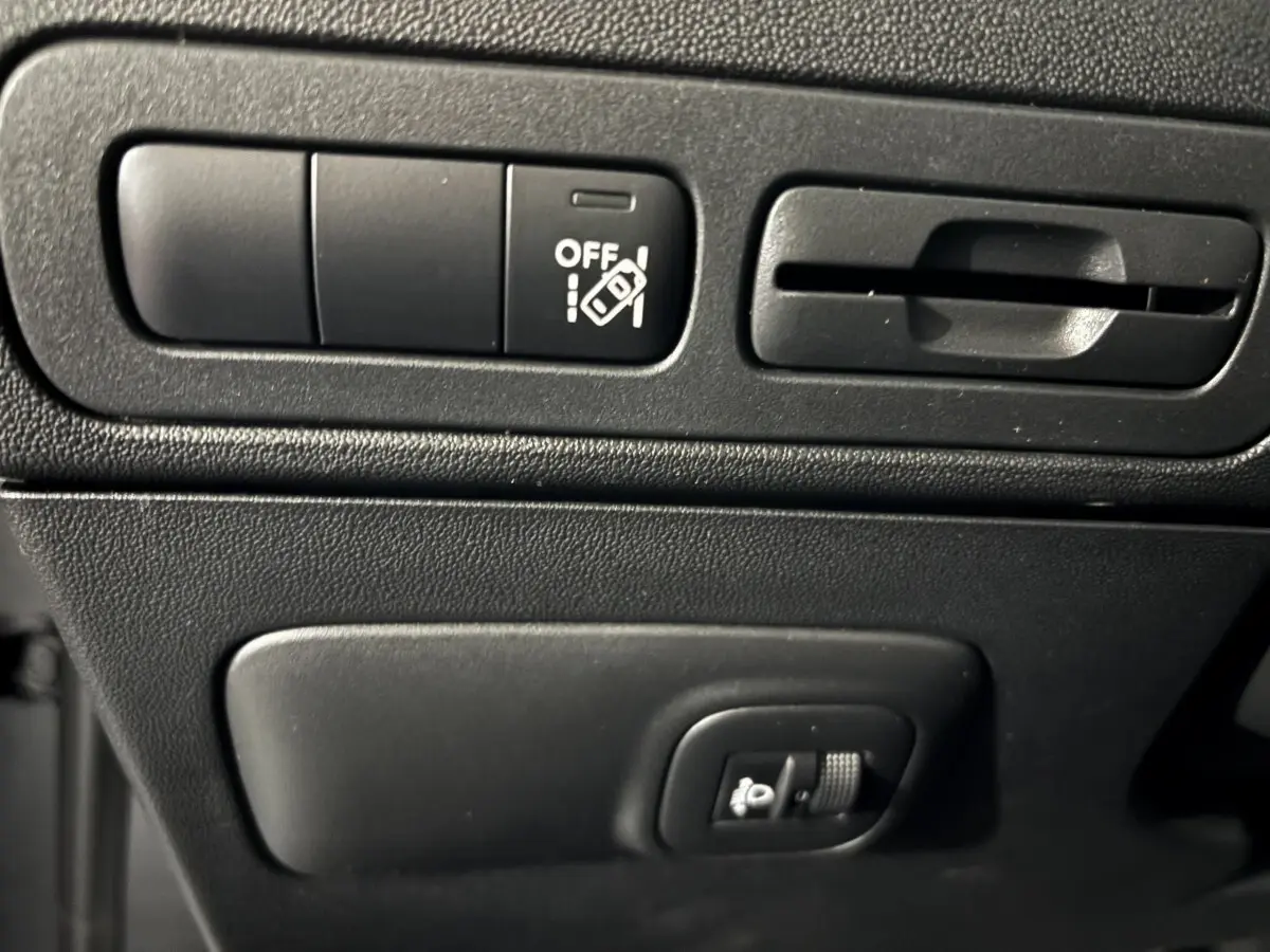 Gros plan sur les commandes de réglage des phares et ventilation du tableau de bord du Citroën C3 Aircross gris foncé 2024.