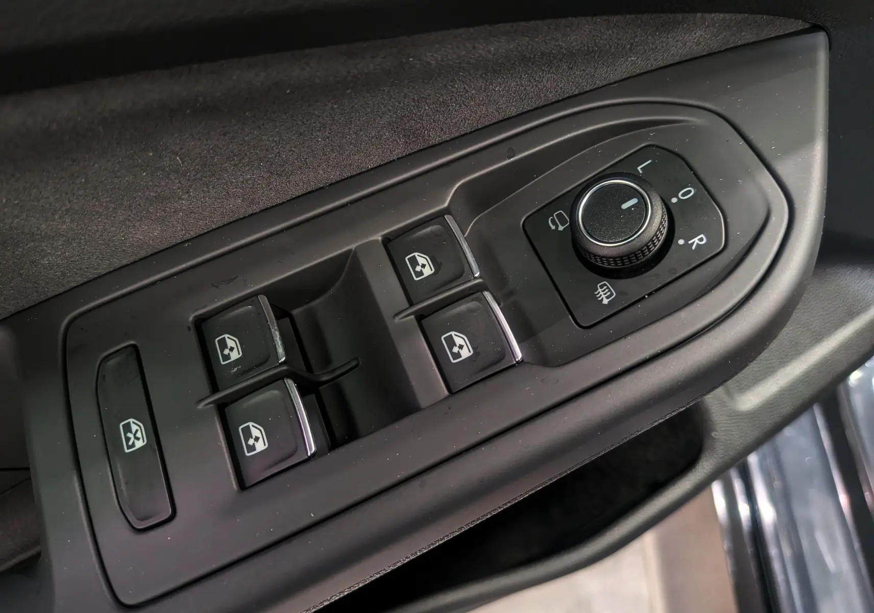 Commande des vitres et réglage des rétroviseurs côté conducteur dans une Volkswagen Golf gris Dauphin 2025 R-Line.