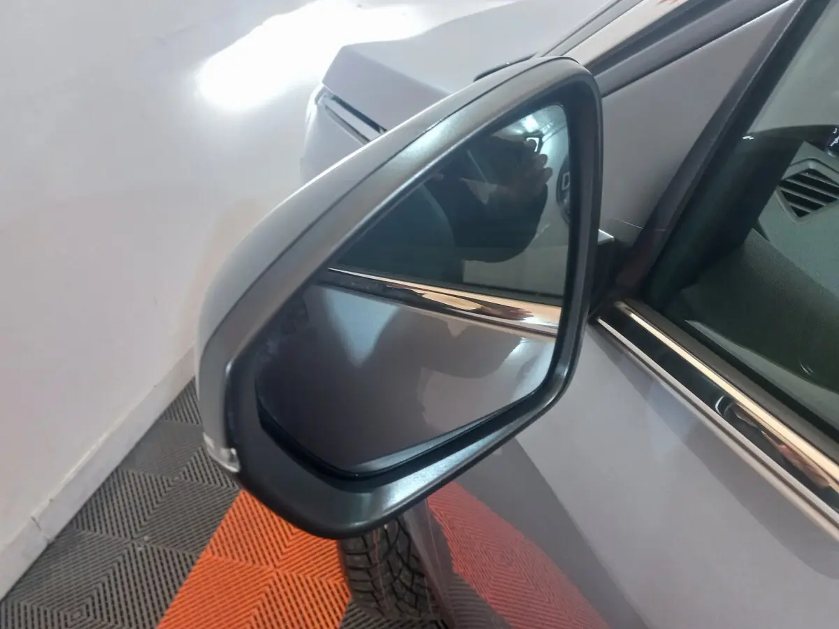 Rétroviseur côté gauche d’un Peugeot 3008 gris clair, vue rapprochée avec reflet et détails de la portière.