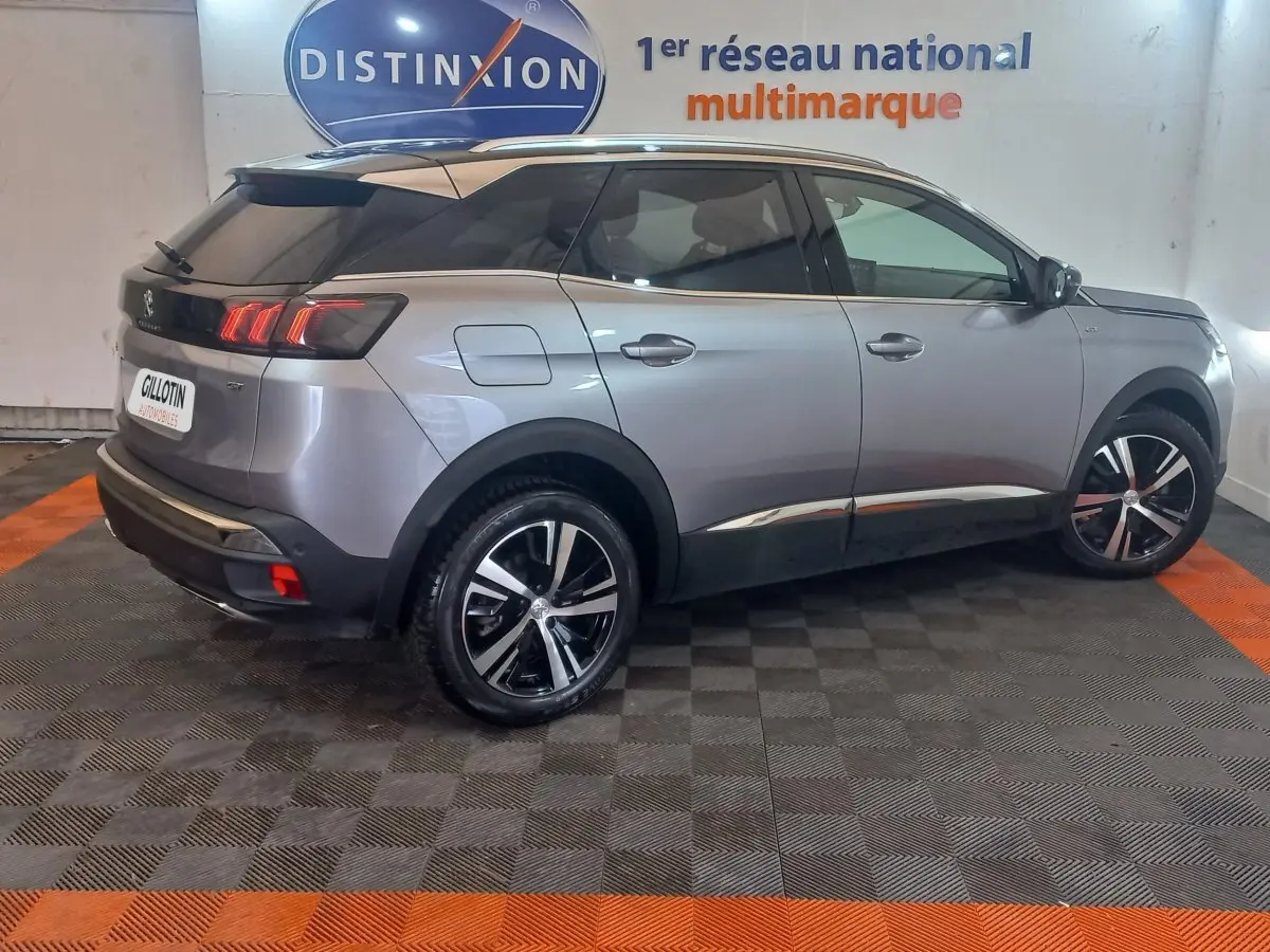 Peugeot 3008 gris clair vue 3/4 arrière droit, avec jantes alliage noires et toit noir brillant.