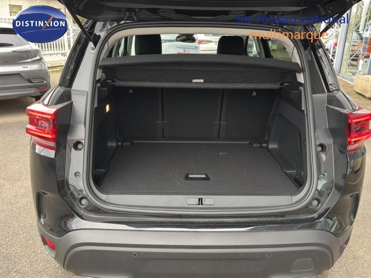 Coffre ouvert vu de l'arrière d'un Citroën C5 Aircross noir métal 2025, montrant un espace de chargement vide.