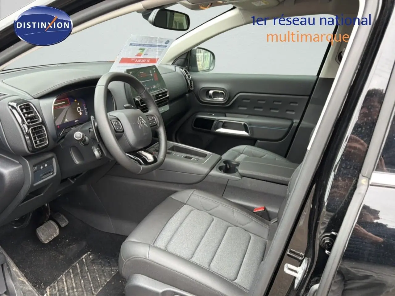 Vue intérieure côté conducteur du Citroën C5 Aircross noir métal 2025, avec tableau de bord et sièges en tissu et cuir.