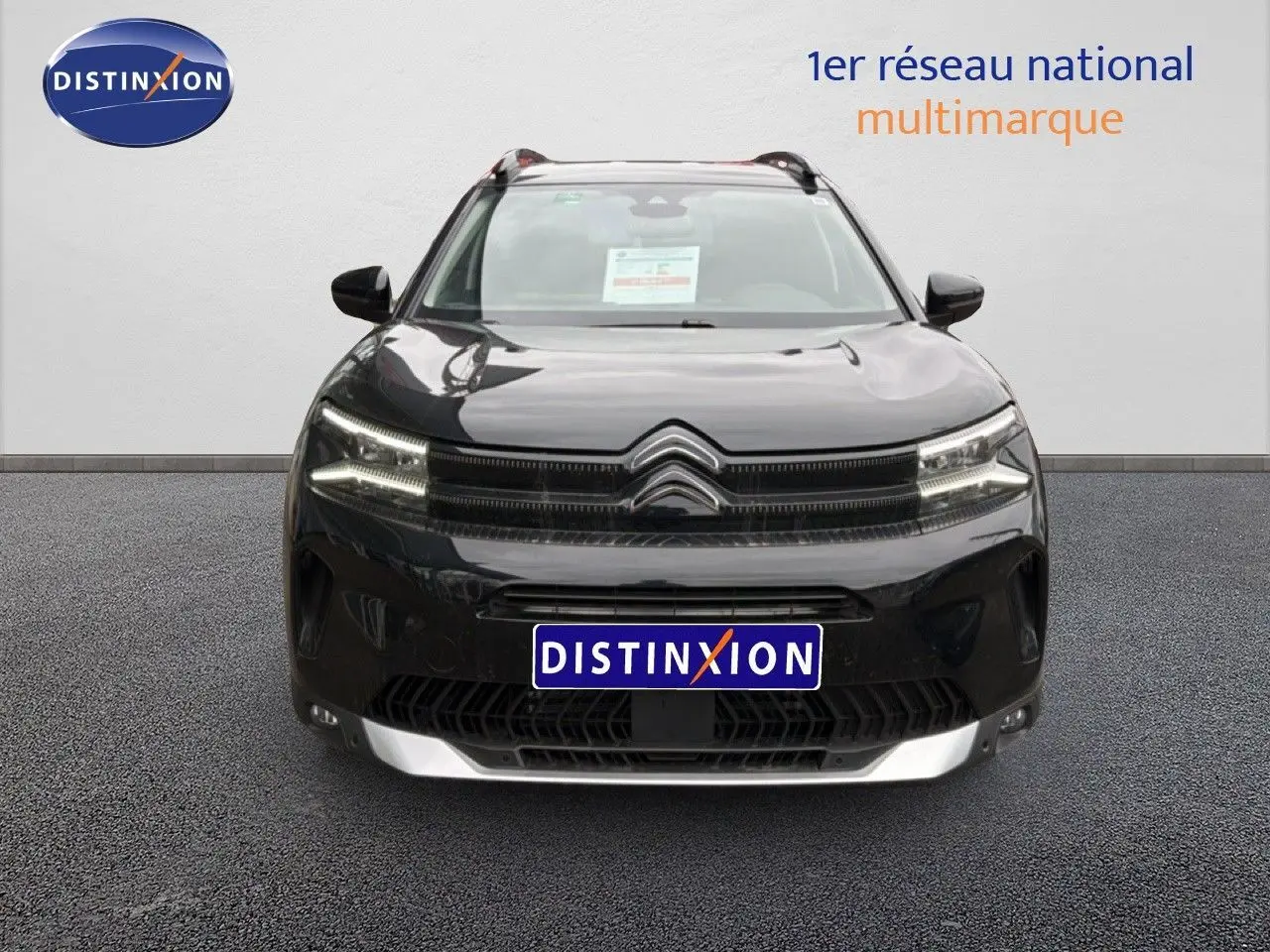 Vue frontale d'un Citroën C5 Aircross noir métal 2025 avec calandre distinctive et phares LED allumés.