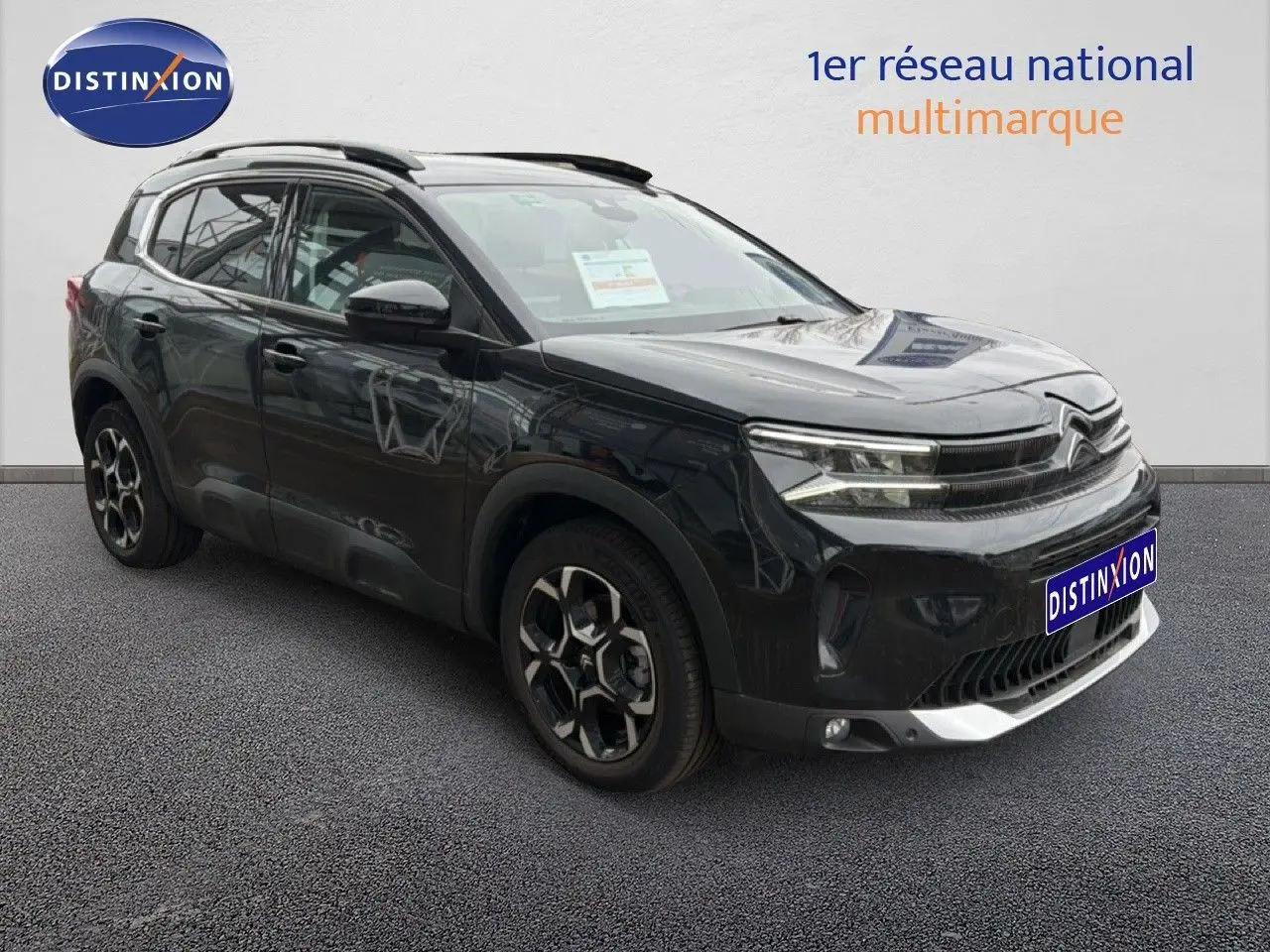 Citroën C5 Aircross noir métal en 3/4 avant droit, avec jantes distinctives et barres de toit visibles.