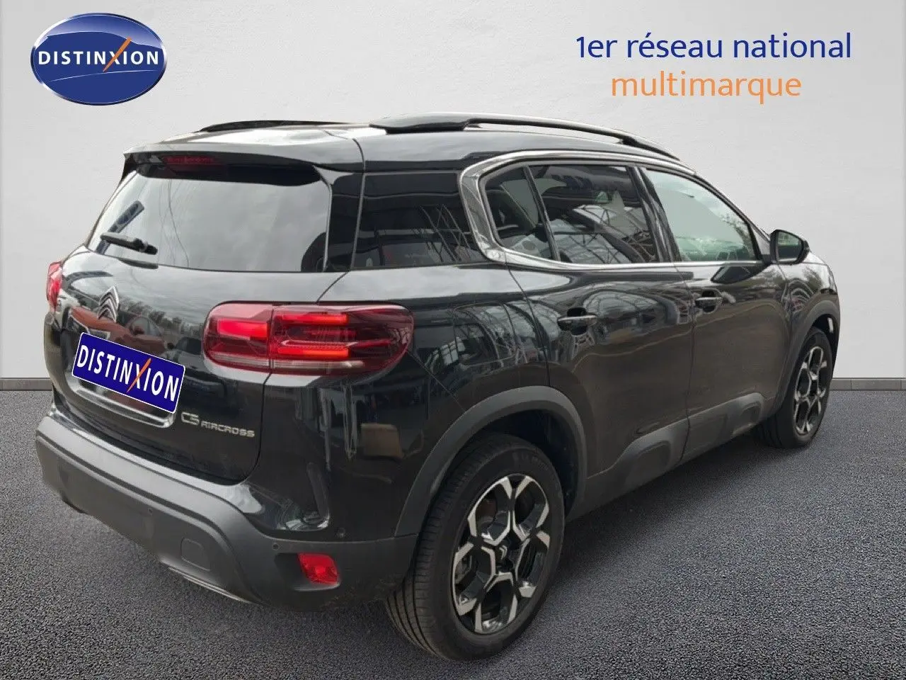 Vue 3/4 arrière droite d’un Citroën C5 Aircross noir métal avec jantes bicolores et vitres teintées.