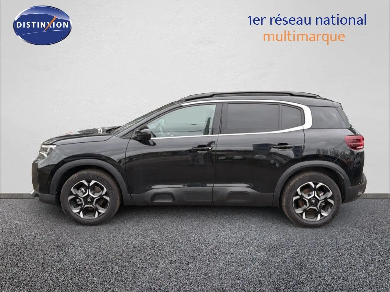 Profil latéral gauche d'un SUV Citroën C5 Aircross noir métal, avec jantes alliage bicolores et cadre de vitre chromé.