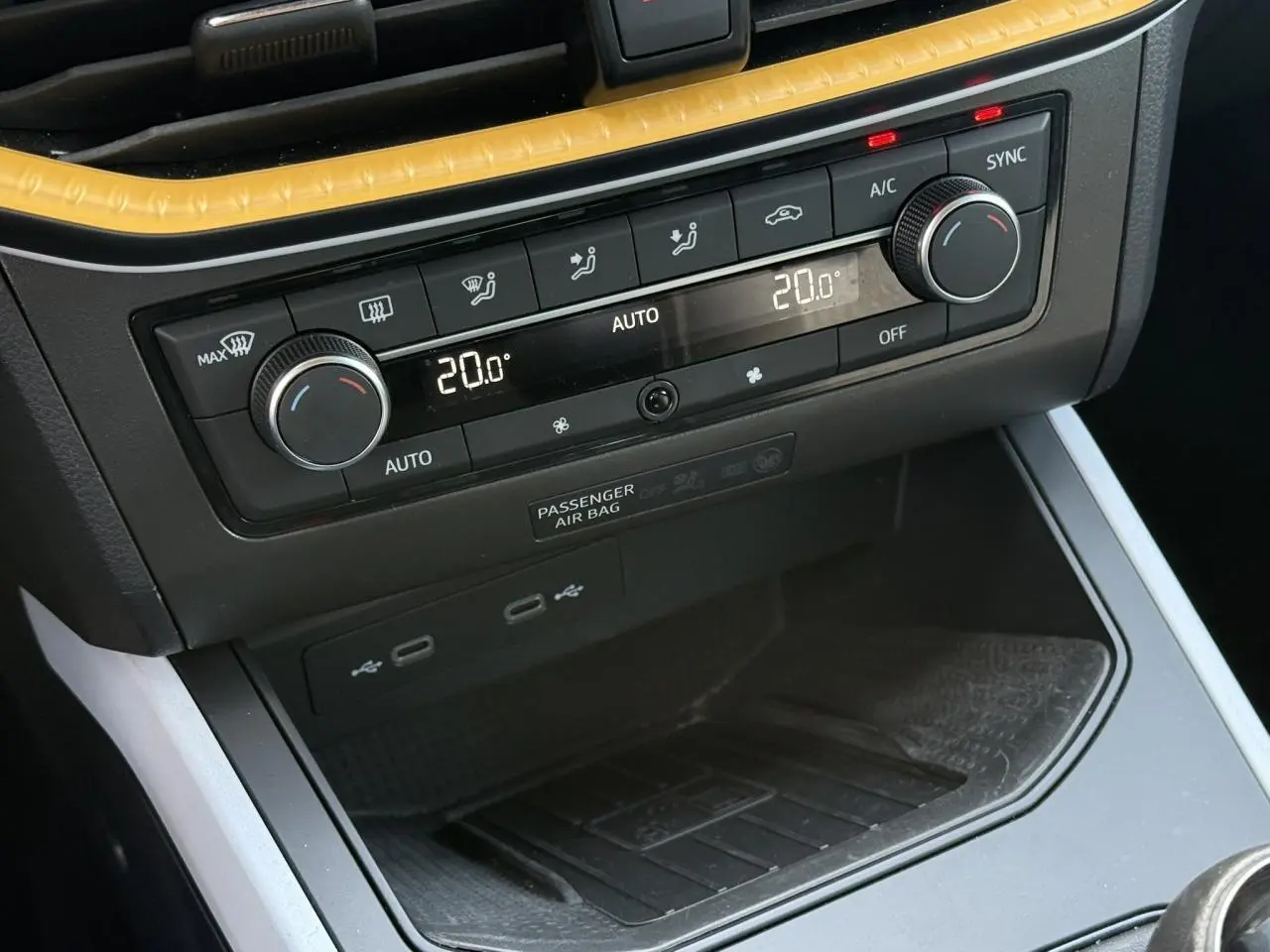 Gros plan sur la console centrale du SEAT Arona 2025, montrant la climatisation automatique bi-zone et ports USB.