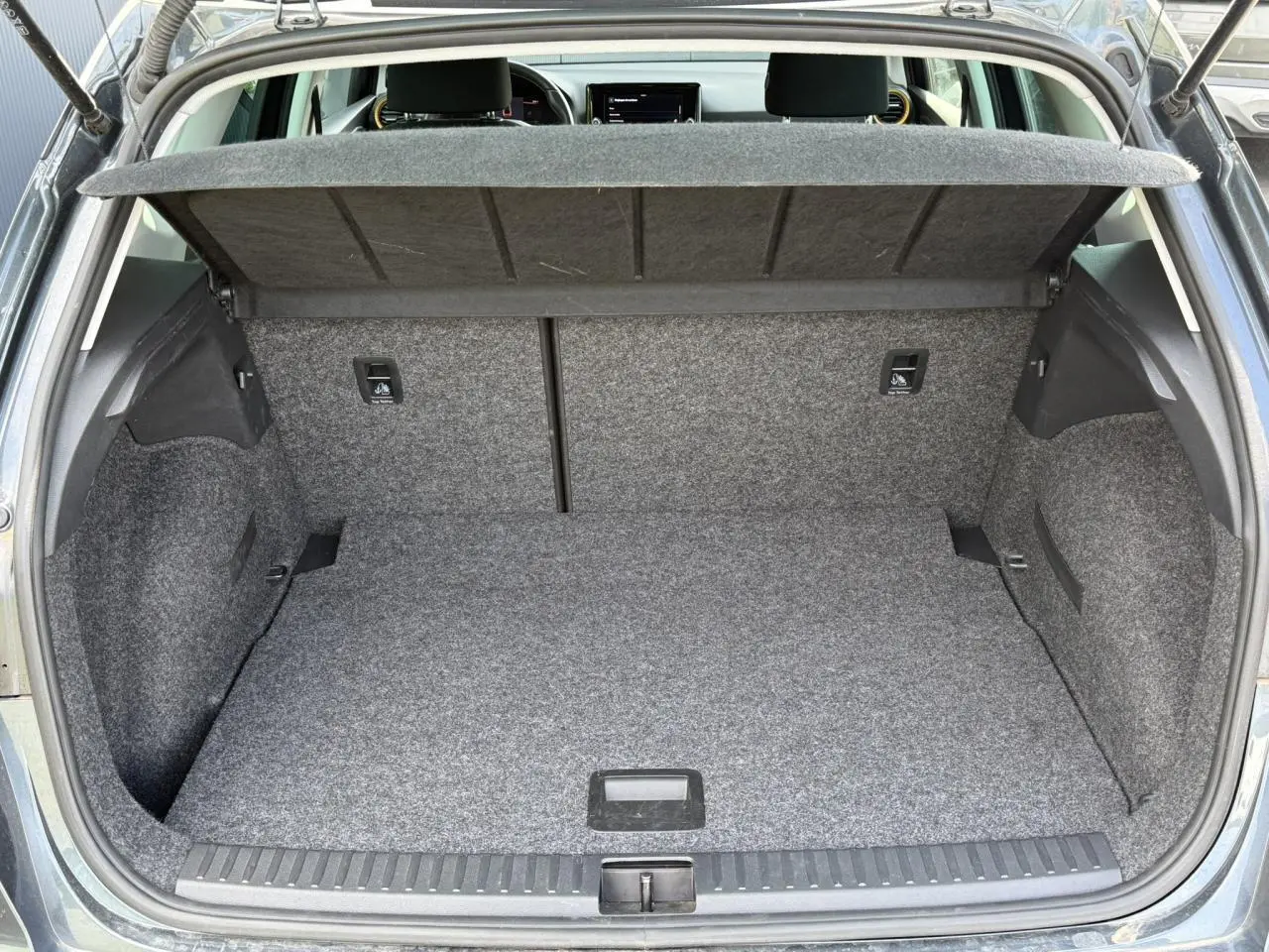 Coffre ouvert du SEAT Arona gris magnétique, vue arrière montrant l’espace de chargement et la tablette cache-bagages.