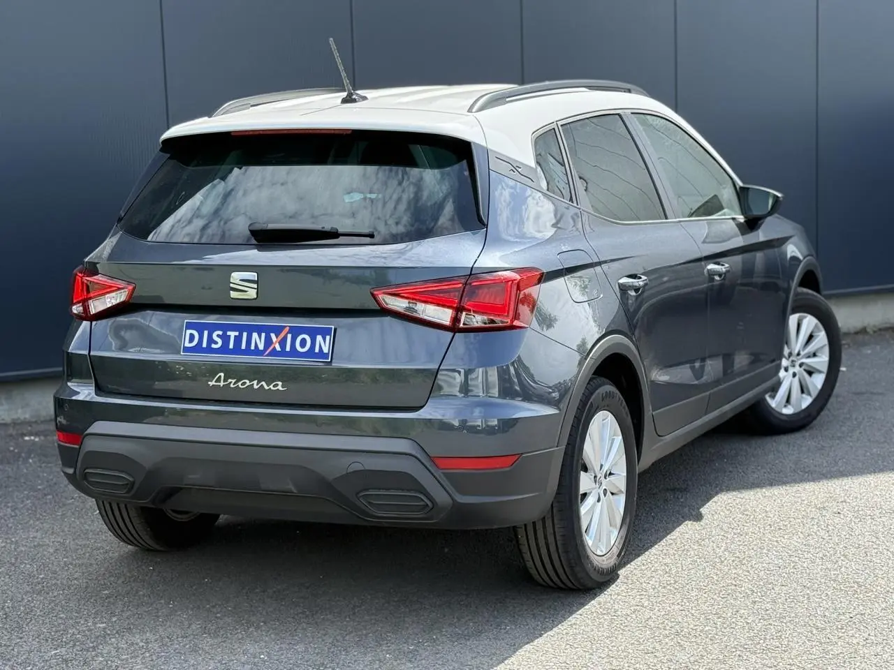 Vue 3/4 arrière droite d’un SEAT Arona gris magnétique avec toit blanc et vitres arrière surteintées.