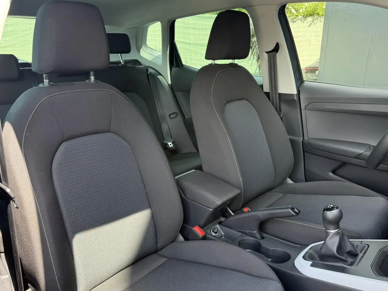 Vue intérieure des sièges avant noirs et de la console centrale avec levier de vitesse manuelle du SEAT Arona TSI 115 Style 2025.