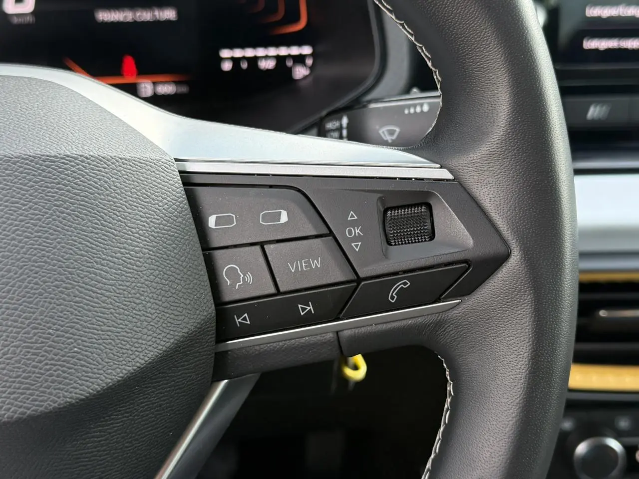 Gros plan sur les commandes multifonctions à gauche du volant du SEAT Arona TSI 115 Style 2025.