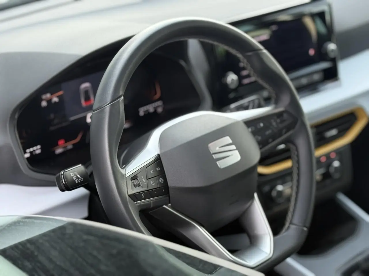 Vue rapprochée du volant noir et du tableau de bord digital du SEAT Arona TSI 115 Style 2025, intérieur moderne.