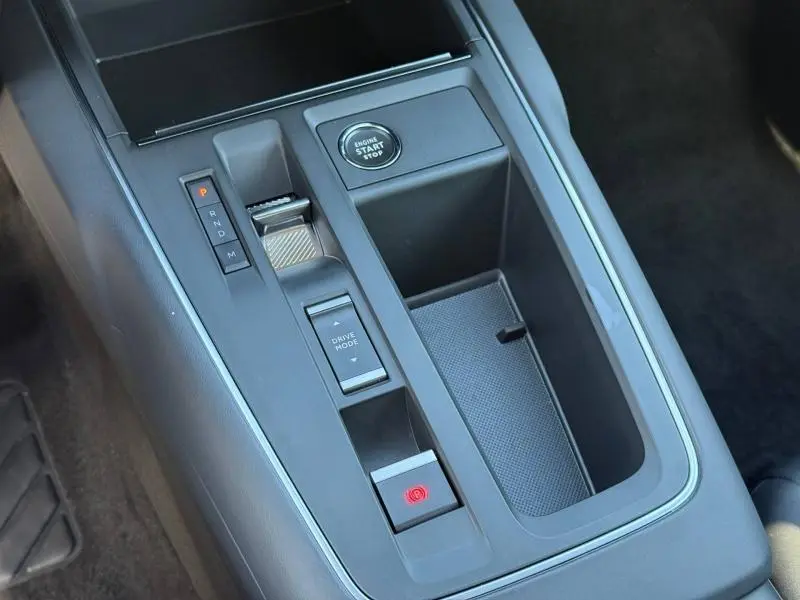 Vue rapprochée de la console centrale du Citroën C5 Aircross 2025 avec levier de boîte auto, bouton start/stop et rangement noir.