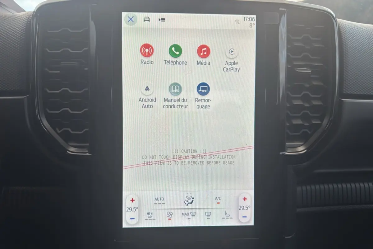 Écran tactile central du Ford Ranger 2026, affichant les options multimédia et climatisation, intérieur noir.