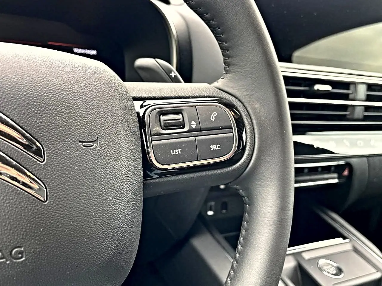 Gros plan sur le volant noir du Citroën C5 Aircross 2025 avec commandes intégrées côté droit et tableau de bord en arrière-plan.