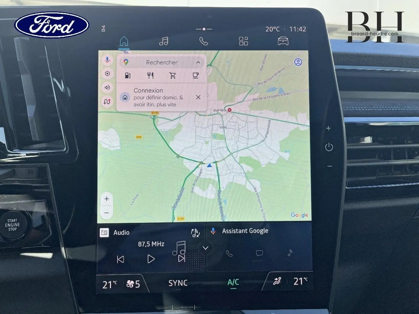 Écran tactile central du tableau de bord du Renault Austral bleu Iron, affichant la navigation GPS et les commandes multimédia.