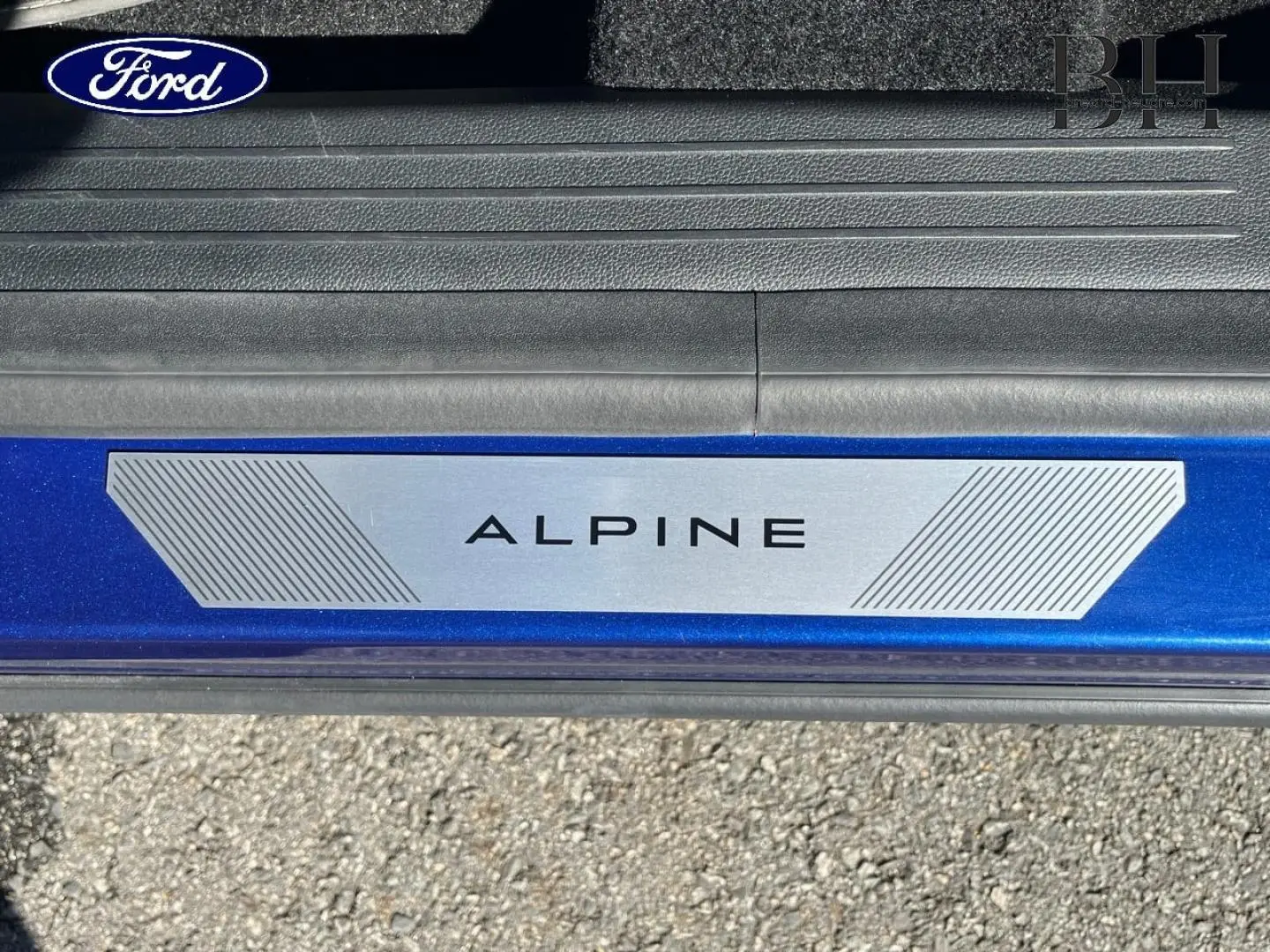 Gros plan sur la plaque de seuil de porte Alpine sur un Renault Austral Bleu Iron, vue côté gauche.