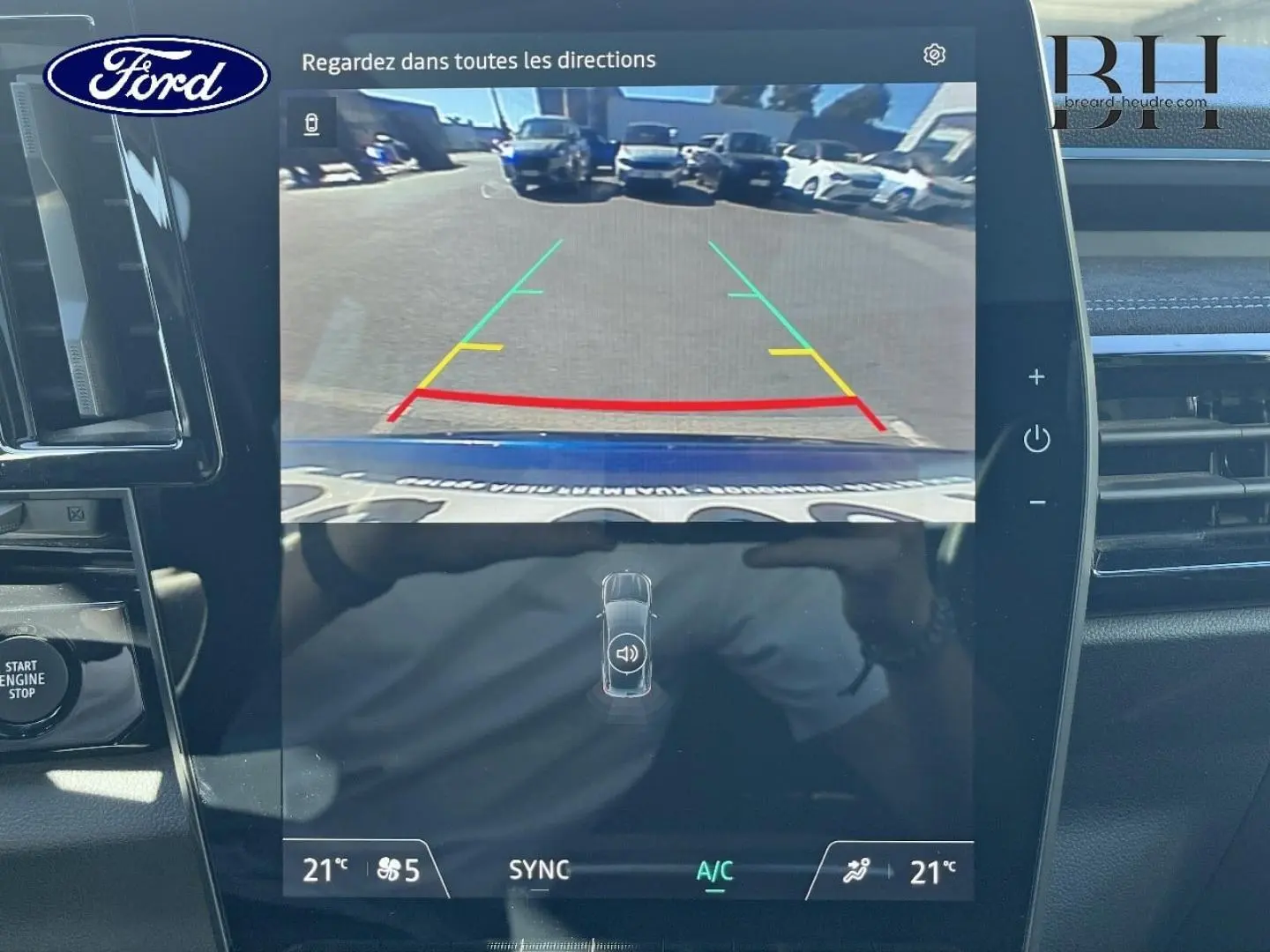Écran tactile intérieur montrant la caméra de recul d'un Renault Austral Bleu Iron en stationnement.