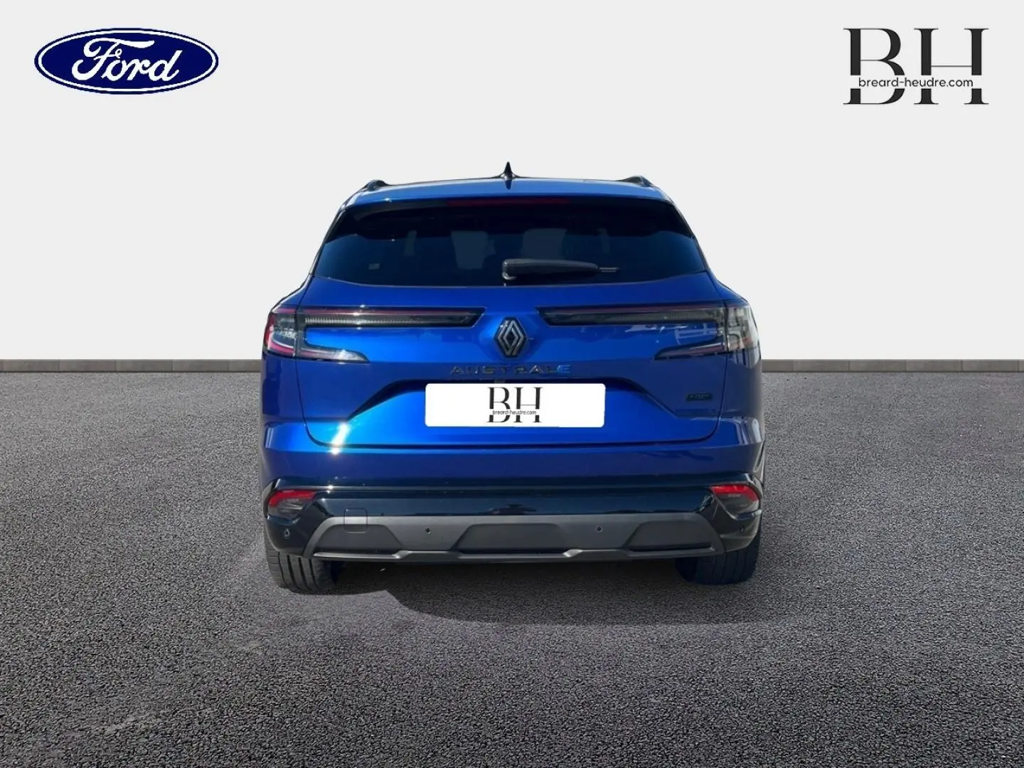 Vue arrière d'un Renault Austral bleu Iron 2023 avec feux LED étirés et becquet arrière noir brillant.