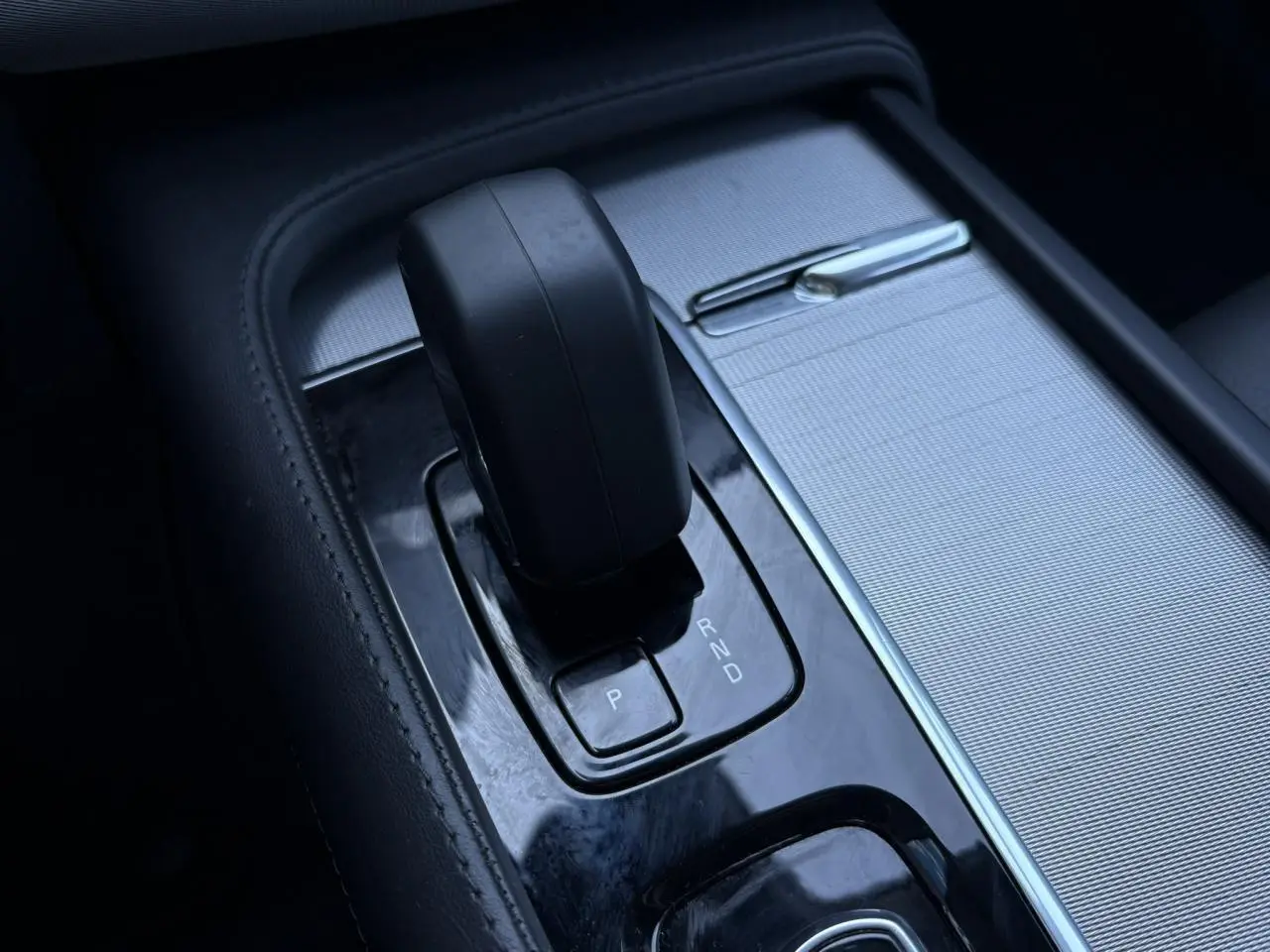 Gros plan sur le levier de vitesses automatique noir et la console argentée du Volvo XC90 T8 hybride 2024.
