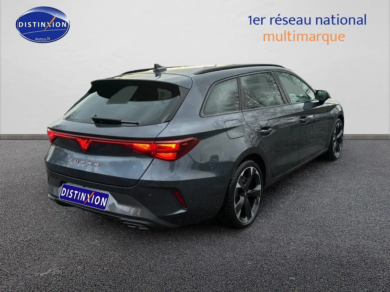 Vue 3/4 arrière droite d'une CUPRA Leon ST gris magnétique avec feux arrière LED allumés et jantes alu noires.