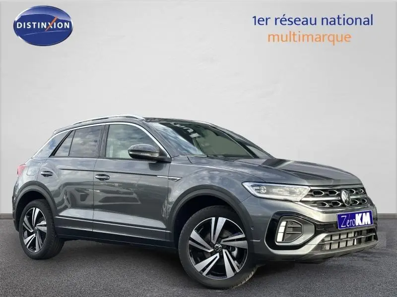 Volkswagen T-Roc gris en 3/4 avant droit, finition R-Line avec jantes alliage distinctives et calandre chromée.
