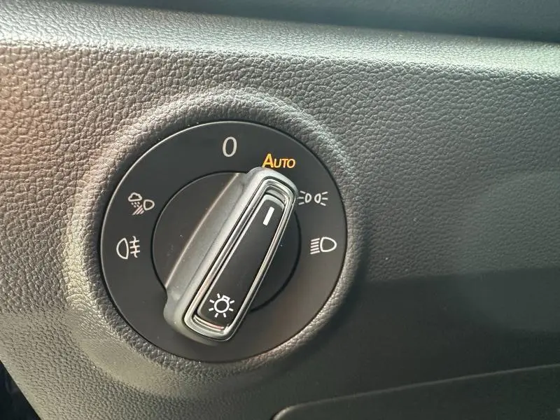 Gros plan sur le sélecteur de phares du Volkswagen T-Roc 2025 gris, montrant le réglage automatique des feux.