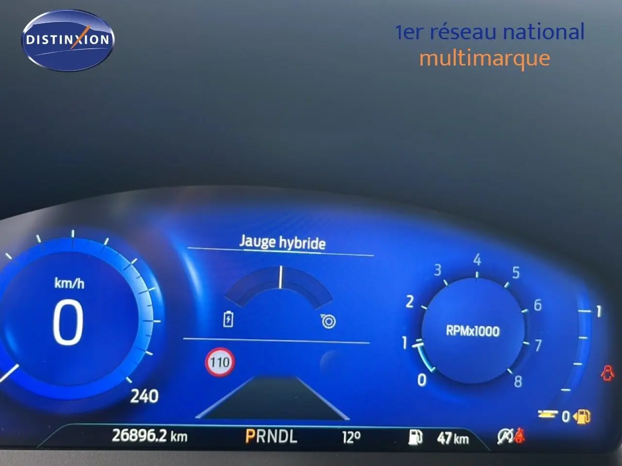 Tableau de bord numérique bleu du Ford Puma 2024 hybride montrant vitesse, régime moteur et jauge hybride.