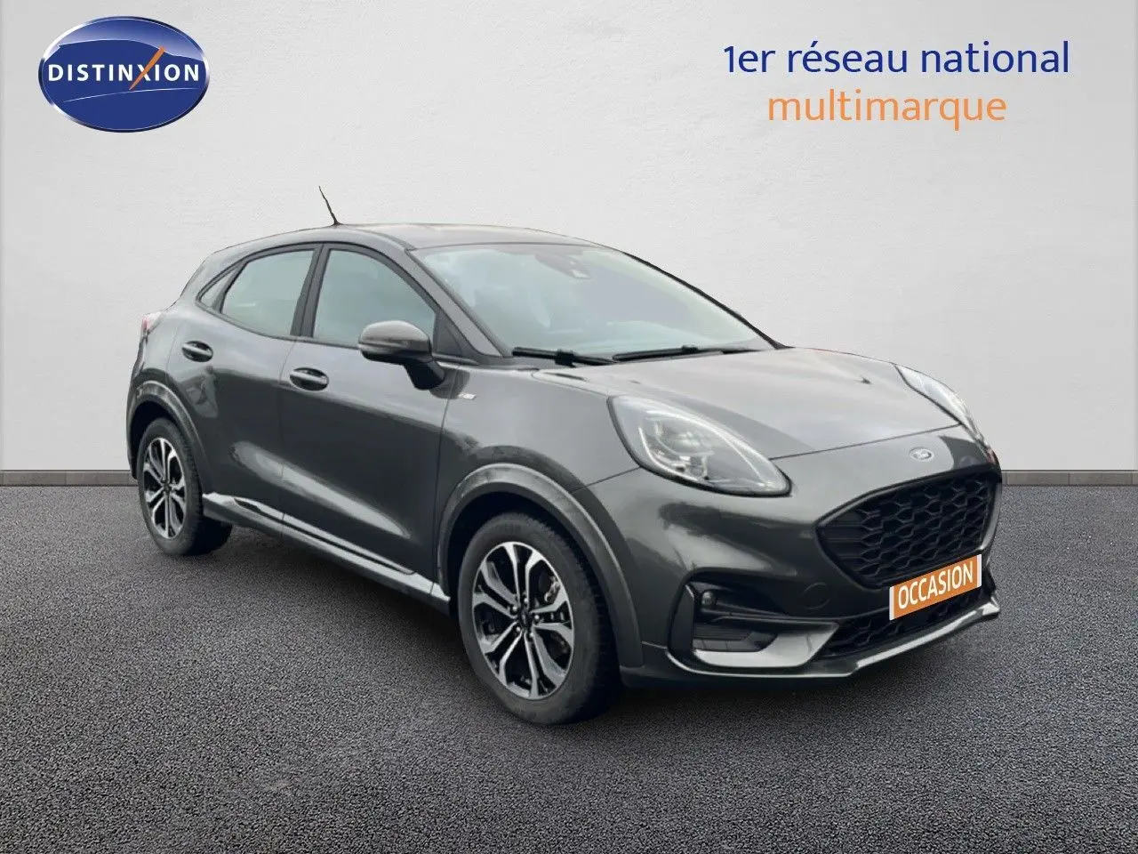 Ford Puma gris magnétique en 3/4 avant droit, avec calandre noire et jantes alliage distinctives.
