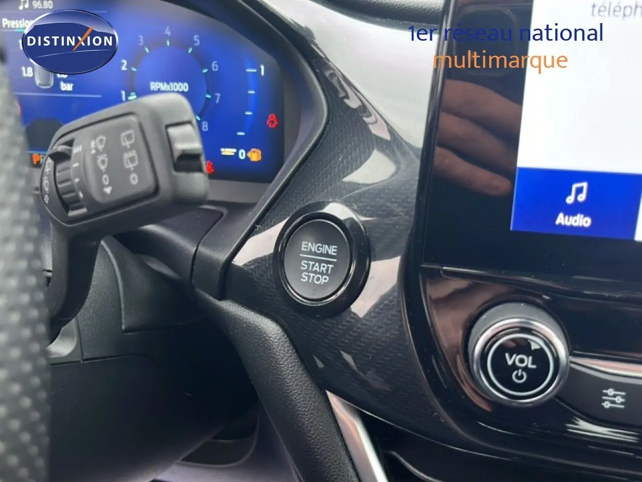 Détail intérieur du tableau de bord du Ford Puma gris magnétique 2024, avec bouton start/stop et commandes audio visibles.